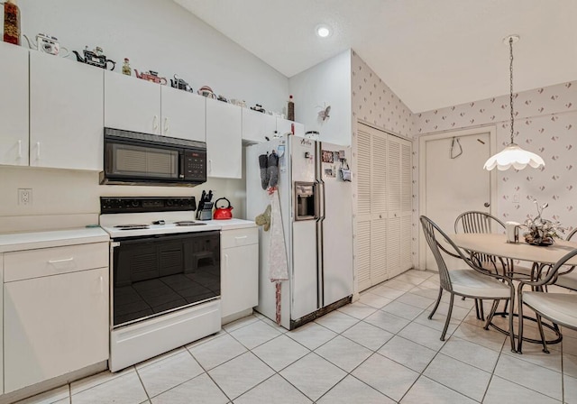 kitchen with white appliances, hanging light fixtures, vaulted ceiling, light tile patterned floors, and white cabinetry