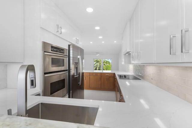 kitchen with white cabinets, stainless steel appliances, and tasteful backsplash