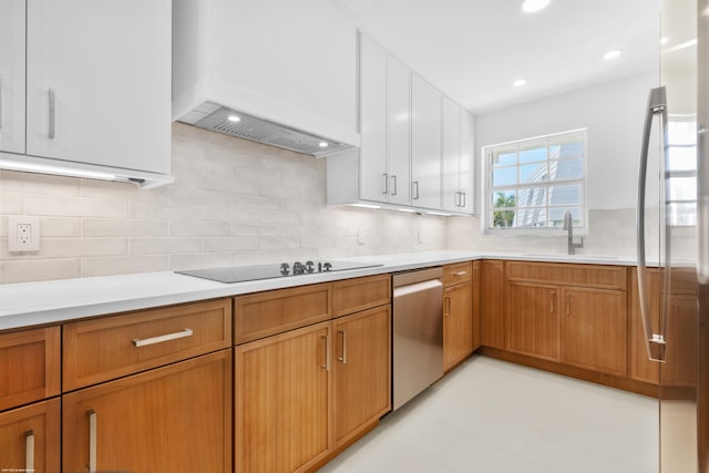 kitchen with backsplash, custom range hood, stainless steel appliances, sink, and white cabinets