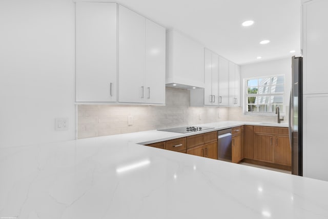 kitchen featuring light stone countertops, appliances with stainless steel finishes, backsplash, sink, and white cabinets