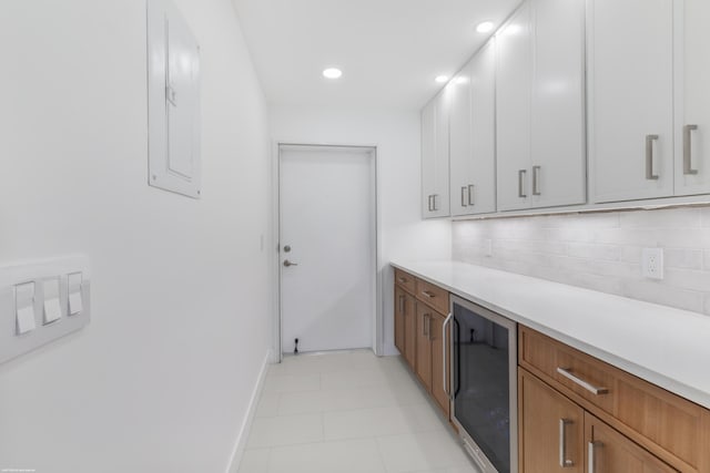 kitchen with decorative backsplash, wine cooler, electric panel, and white cabinetry