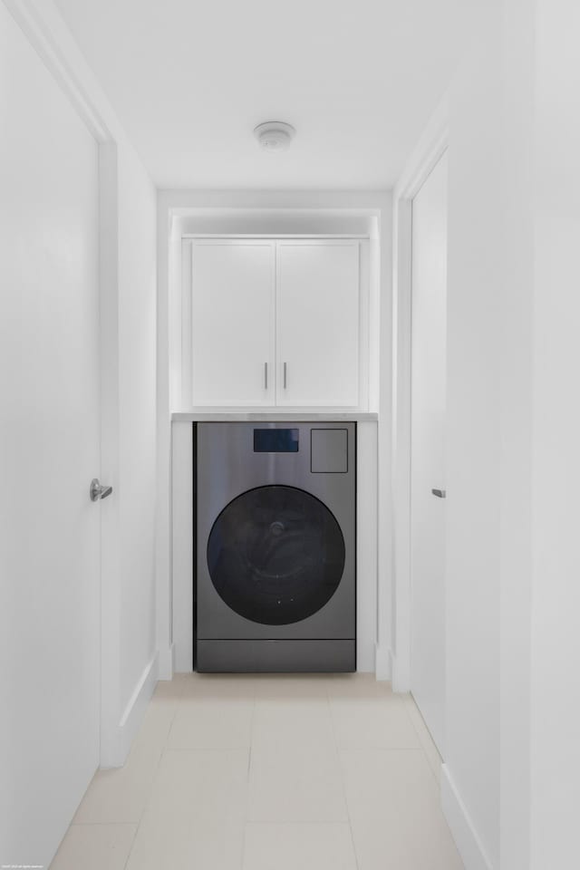 washroom with cabinets, washer / dryer, and light tile patterned floors