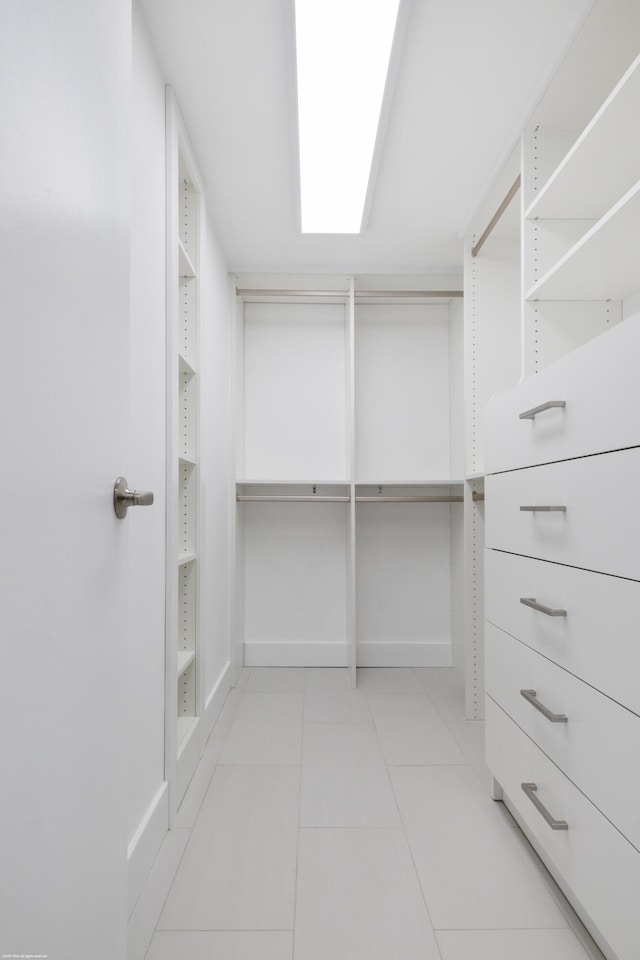 walk in closet with light tile patterned floors