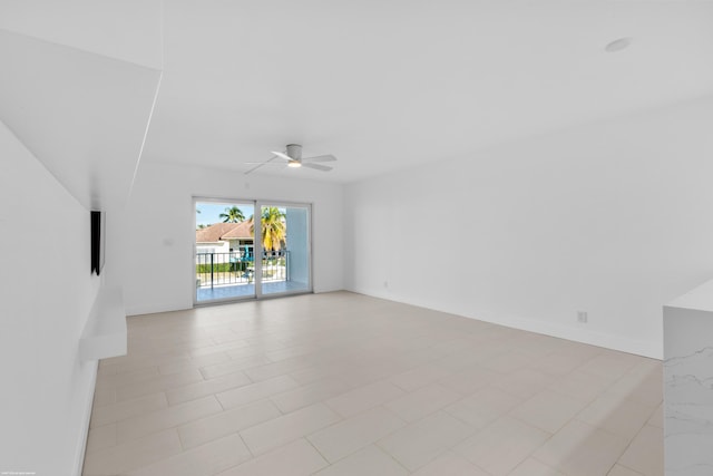 tiled spare room with ceiling fan