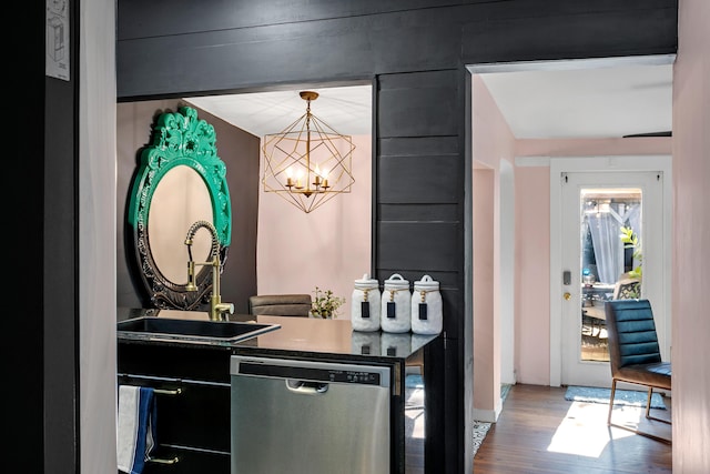 bar featuring sink, an inviting chandelier, hanging light fixtures, dishwasher, and hardwood / wood-style floors