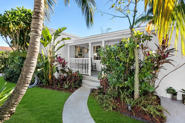 property entrance featuring a porch and a yard