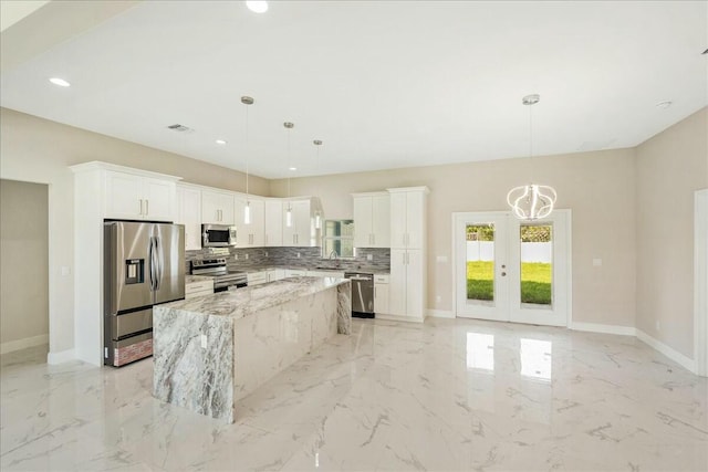 kitchen with white cabinetry, decorative light fixtures, and appliances with stainless steel finishes