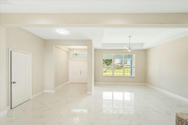 unfurnished room featuring a raised ceiling and ceiling fan