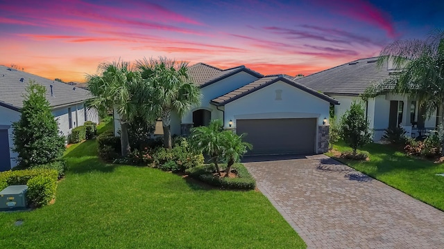 view of front of property with a garage and a yard