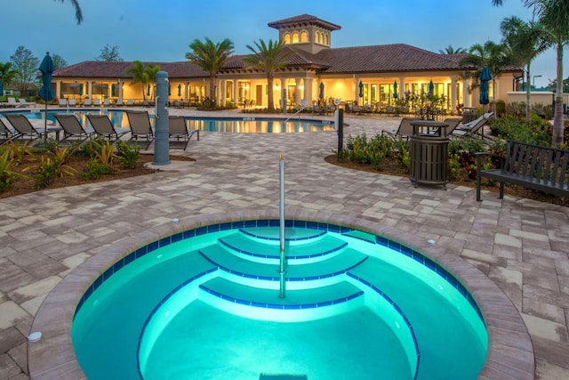 pool at dusk with a patio area