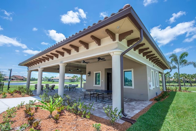 exterior space featuring a patio, ceiling fan, and a lawn