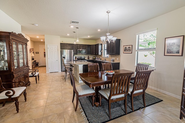 tiled dining room featuring a notable chandelier and sink