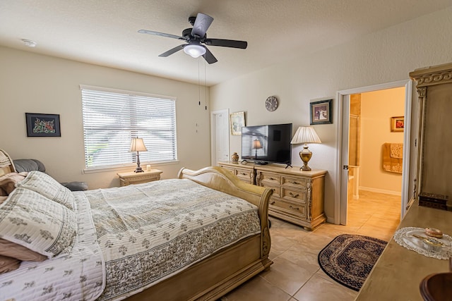 bedroom with ceiling fan, ensuite bathroom, and light tile patterned floors