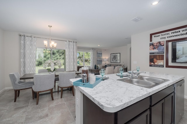 kitchen with sink, dishwasher, hanging light fixtures, a notable chandelier, and a kitchen island with sink