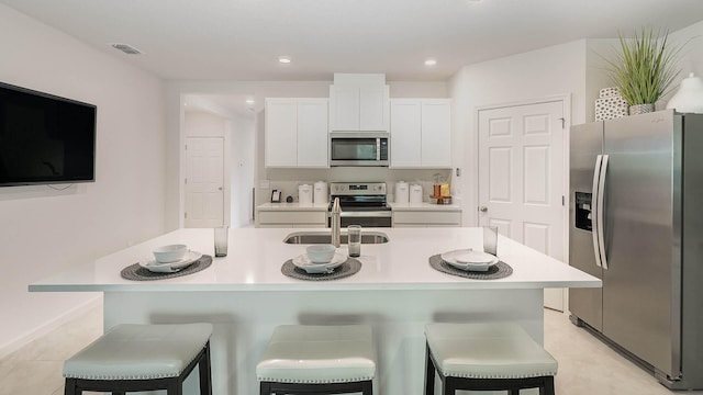 4601 SW Savona Blvd, Port Saint Lucie, FL 34953 - kitchen with a kitchen bar, white cabinets, visible vents, appliances with stainless steel finishes, and light countertops