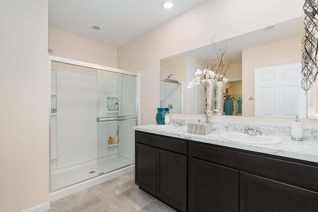 bathroom featuring a shower with door and vanity