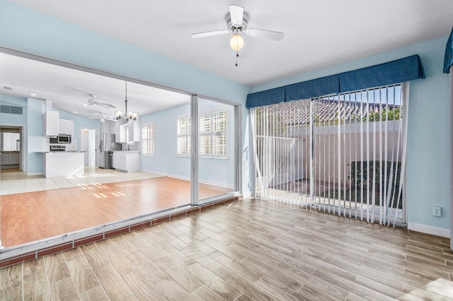 exercise area with a chandelier and light hardwood / wood-style flooring