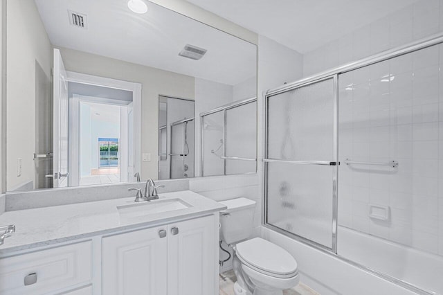 full bathroom with shower / bath combination with glass door, vanity, and toilet