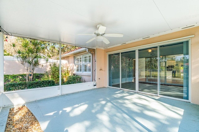 unfurnished sunroom featuring ceiling fan