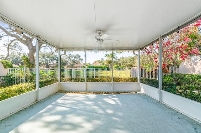 unfurnished sunroom featuring ceiling fan and a healthy amount of sunlight