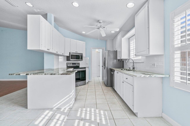 kitchen with white cabinets, appliances with stainless steel finishes, a healthy amount of sunlight, and sink