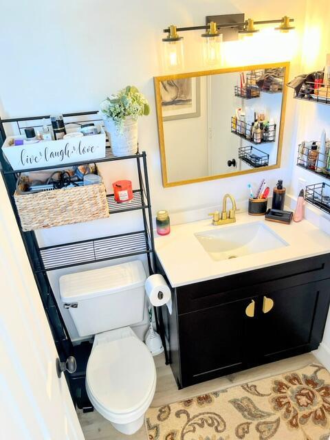 bathroom with hardwood / wood-style flooring, vanity, and toilet