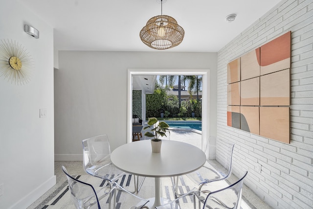 dining area featuring brick wall