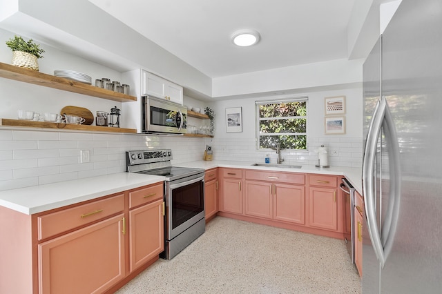 kitchen with appliances with stainless steel finishes, backsplash, and sink