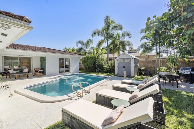 view of pool featuring a storage unit, area for grilling, and a patio