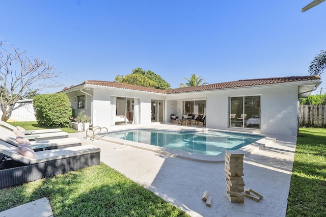 rear view of house featuring a patio and a fenced in pool