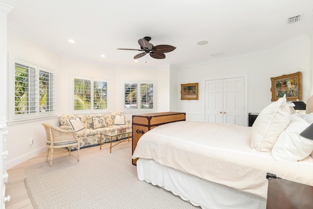 bedroom featuring ceiling fan, light wood-type flooring, crown molding, and multiple windows