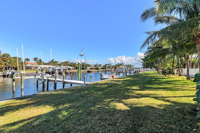 dock area with a lawn and a water view