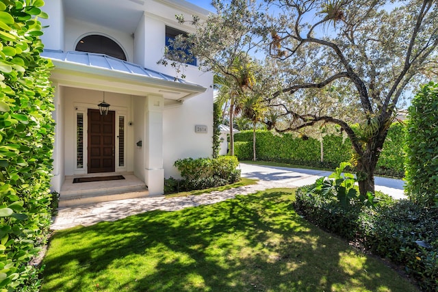 property entrance featuring a lawn