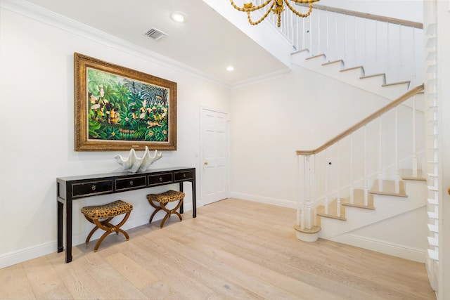 foyer entrance with crown molding and wood-type flooring