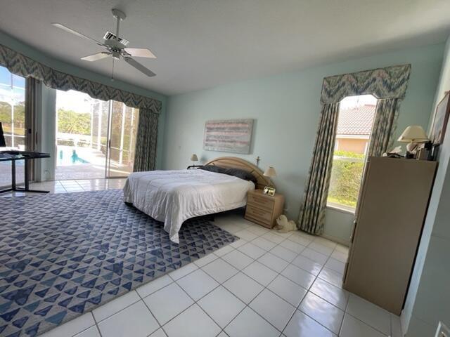 bedroom featuring access to exterior, ceiling fan, and light tile patterned flooring