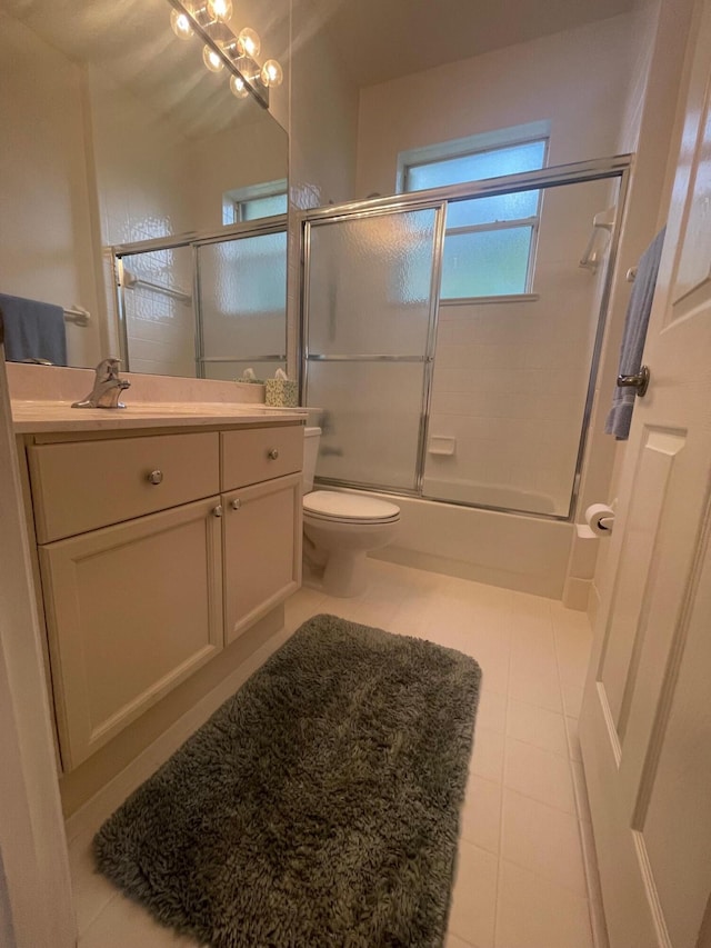 full bathroom featuring toilet, shower / bath combination with glass door, tile patterned floors, and vanity