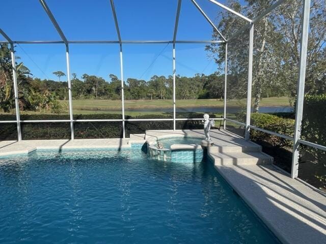 view of pool with a patio area, a pool with connected hot tub, and glass enclosure