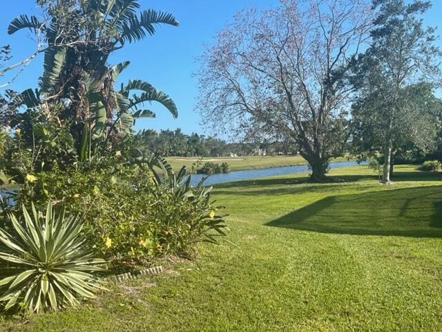 view of community featuring a water view and a yard