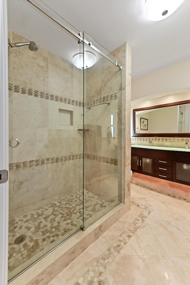 bathroom featuring vanity and a shower with shower door