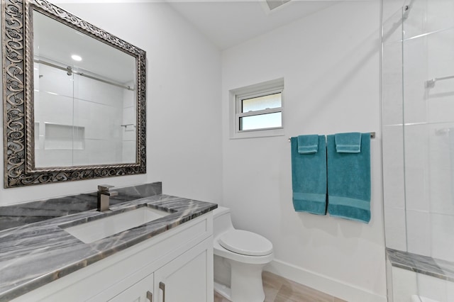 bathroom with vanity, toilet, and a shower with shower door