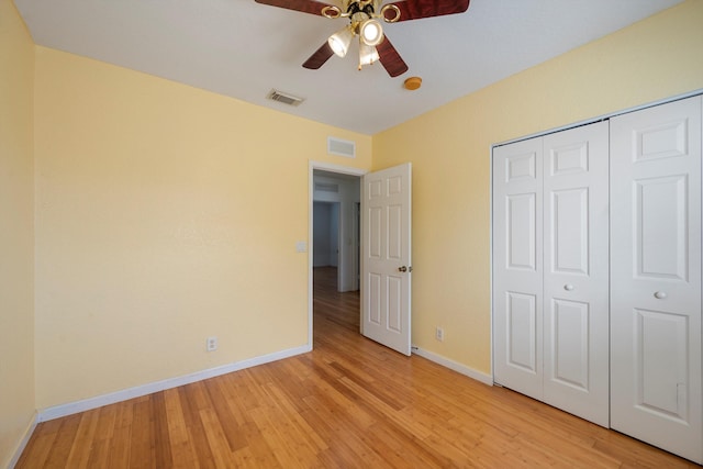 unfurnished bedroom with ceiling fan, a closet, and light hardwood / wood-style floors