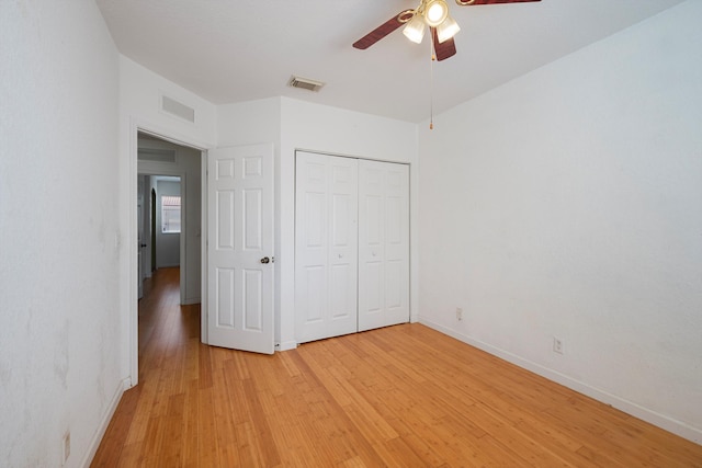 unfurnished bedroom with ceiling fan, a closet, and light hardwood / wood-style flooring