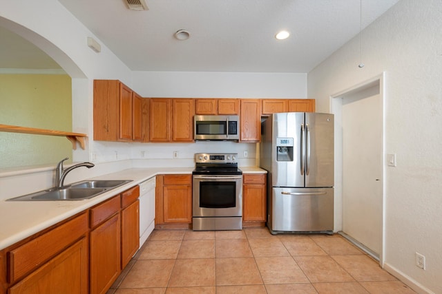 kitchen with light tile patterned flooring, stainless steel appliances, and sink