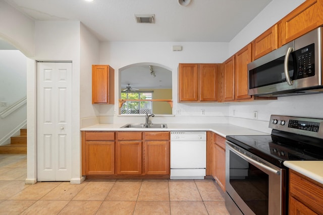 kitchen with appliances with stainless steel finishes, light tile patterned floors, ceiling fan, and sink