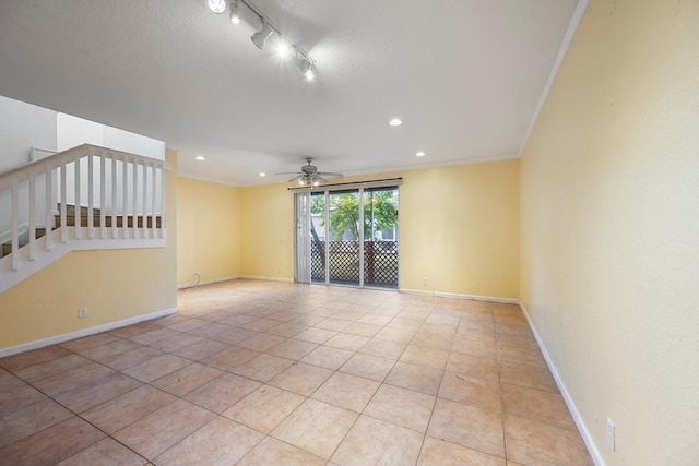 tiled spare room with rail lighting, ceiling fan, and crown molding