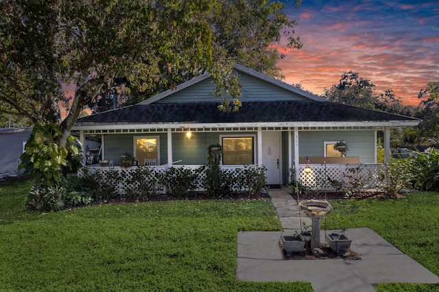 view of front of property with covered porch and a yard