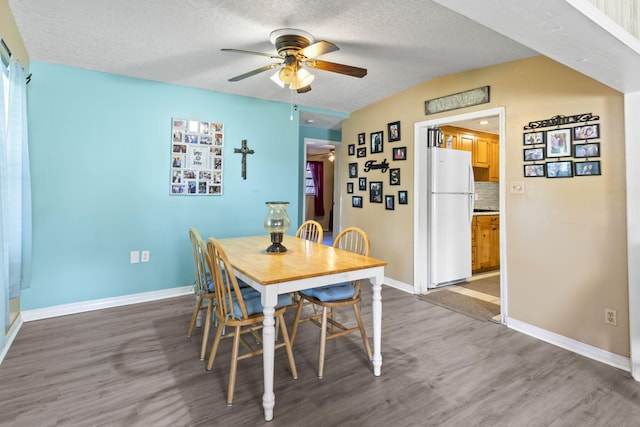 dining space featuring hardwood / wood-style floors, a textured ceiling, and ceiling fan