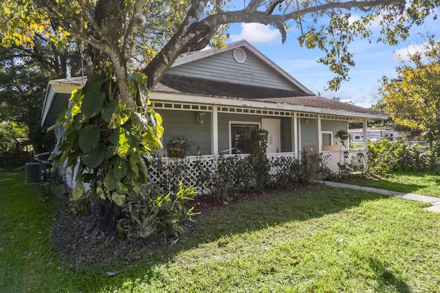 view of front of home with covered porch, a front lawn, and central air condition unit