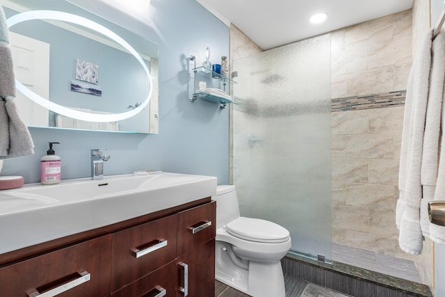 bathroom featuring vanity, toilet, and a shower with door