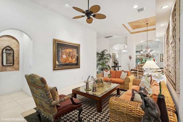 interior space with ceiling fan with notable chandelier and a raised ceiling